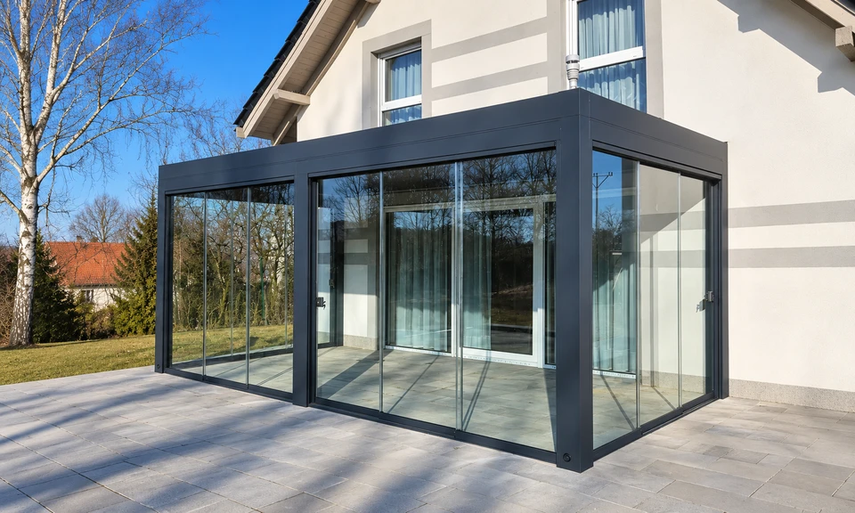 Pergola przy domu z przeszklonymi bokami