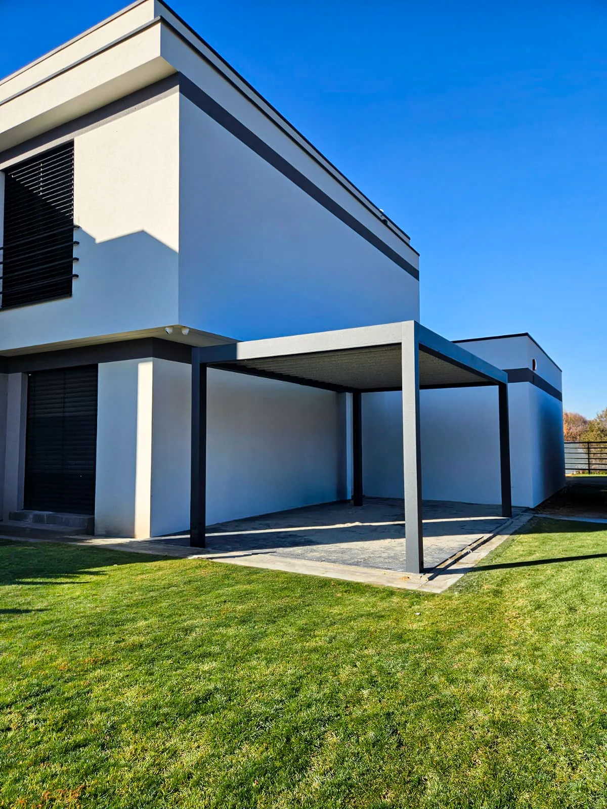 Carport przy jasnym budynku widziany z narożnika