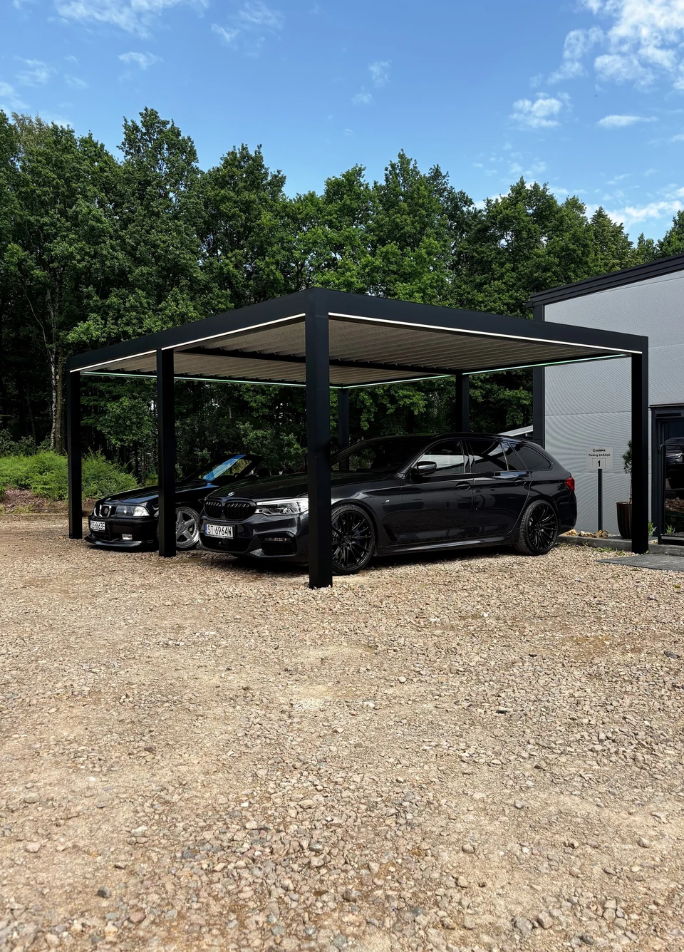 Carport z samochodami przy drzewach