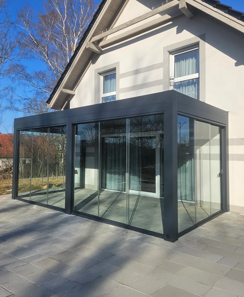 Pergola przy domu z transparentną zabudową boczną ze szklanych tafli