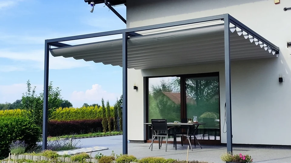 Pergola z jasnym dachem materiałowym nad tarasem przy domu