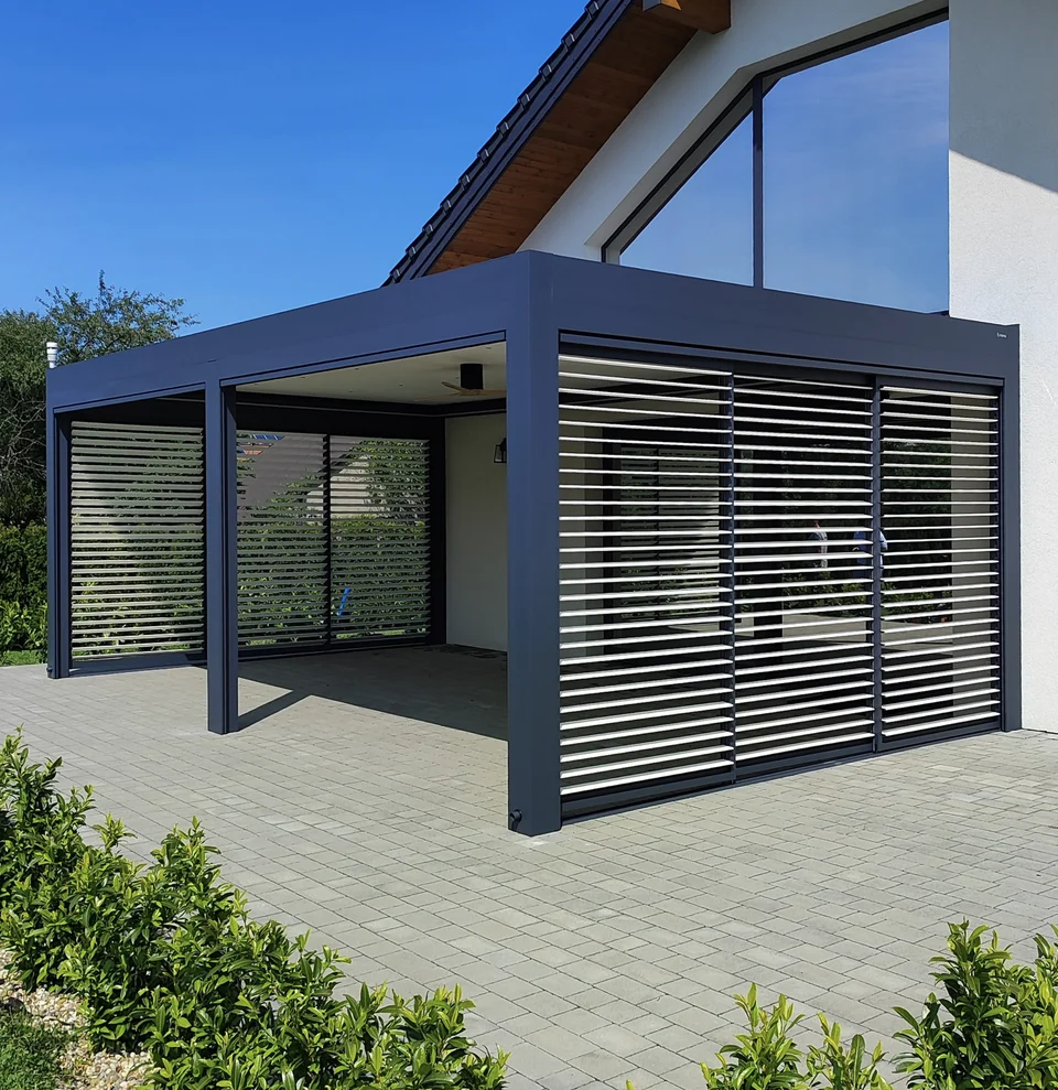 Pergola z boczną ścianą z poziomych lameli przy jasnym domu