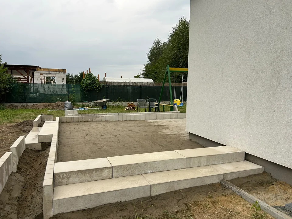 Montaż stopni tarasu przy białej elewacji